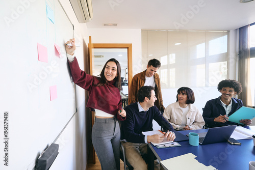 Fotografia Diverse Group of young latin professionals engaged in a discussion at an office,