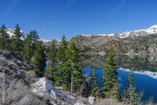 June Lake in the Eastern Sierra Nevada, California, with calm alpine waters reflecting the surrounding Sierra Nevada mountains. 