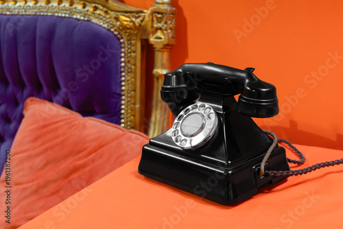 фотографія Vintage black telephone with handset on orange table