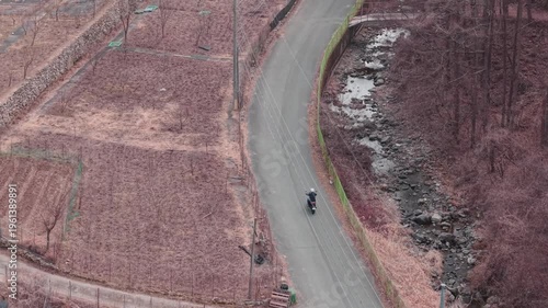 Cinematic motorcycle riding on Scenic route with a mountain creek with synchronized real exhaust sound_Telephoto