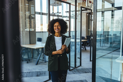 Professional Business Woman Walking Through Modern Glass Office Holding Tablet and Smiling
