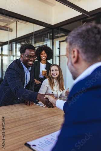 Diverse Business Team Shaking Hands in Modern Office During Successful Meeting and Partnership Agreement