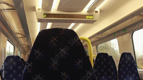 Empty train carriage standing at station with active electronic display. Static shot, autumn day, 4K horizontal transport interior.