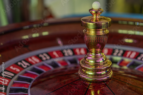 Bild auf Leinwand Close-up of a spinning roulette wheel in a blurred casino interior, featuring al