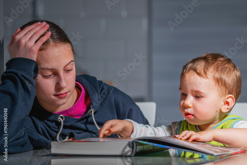 Unposed candid image of children with a book, showing genuine emotions, natural interaction, and authentic learning moment in a home setting.