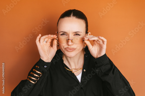 Принти на полотні Young stylish woman squinting eyes to see better or looking with suspicion, hold