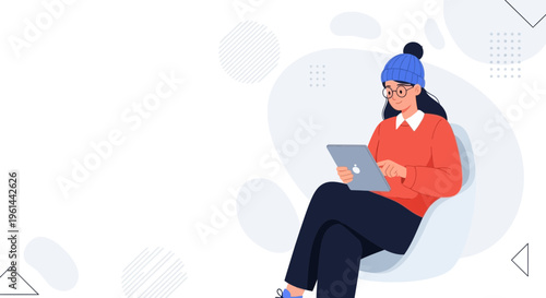 Young woman in winter clothes using laptop while sitting in a chair, minimalist background