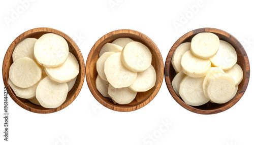 Three wooden bowls filled with sliced, pale, round vegetables against a black background
