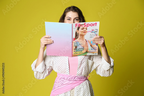 Woman with lifestyle magazine on olive background