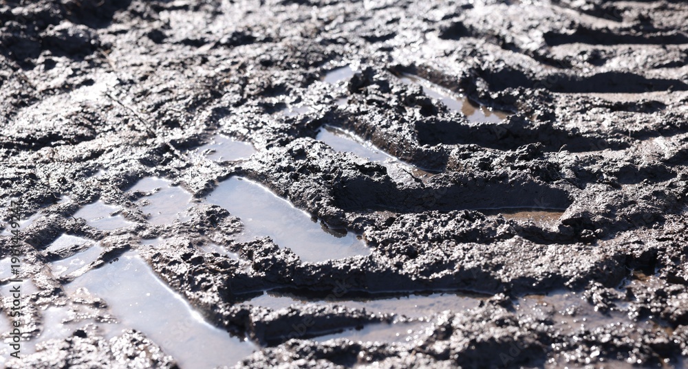 Naklejka premium Ground mud with tire tracks as background, closeup