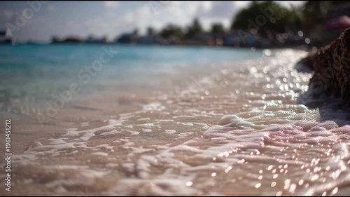 Gentle ocean waves crash onto a tropical beach with sparkling turquoise water and soft golden sand evoking feelings of serenity and coastal relaxation