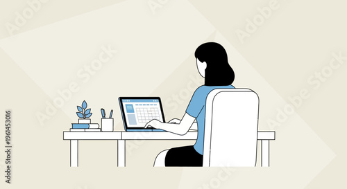 Focused young woman working on her laptop at a desk in a bright studio.