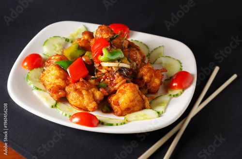 Thai Red Pepper Rosemary Chicken with cucumbers and cherry tomatoes in a white plate; copy space
