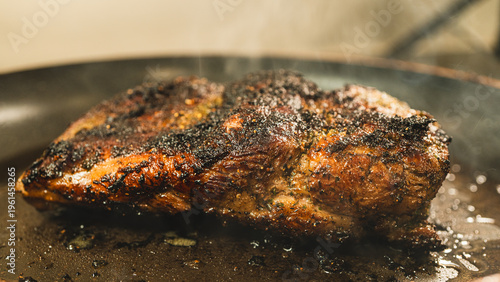 Fotografía Boneless lamb frying in a hot pan with herbs and seasoning, developing a golden crust