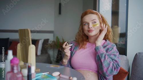 Pregnant Woman applying skincare under eye patches while sitting at a table in a modern apartment during daytime