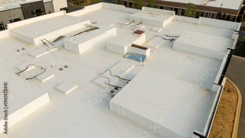 Aerial drone inspection of commercial TPO roof featuring heat-welded seams, HVAC curb flashing, and pipe penetrations.