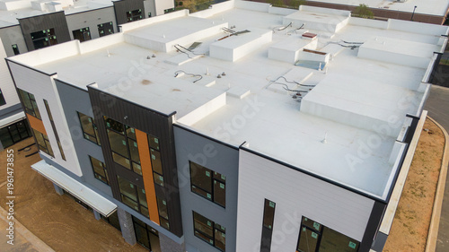 Aerial drone inspection of commercial TPO roof featuring heat-welded seams, HVAC curb flashing, and pipe penetrations.