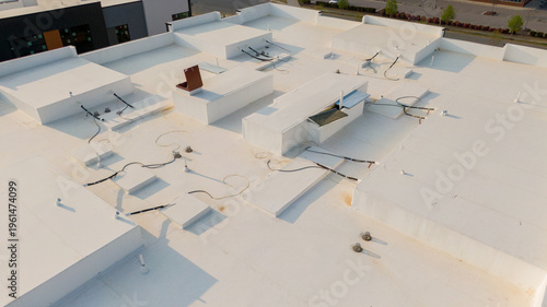 Aerial drone inspection of commercial TPO roof featuring heat-welded seams, HVAC curb flashing, and pipe penetrations.