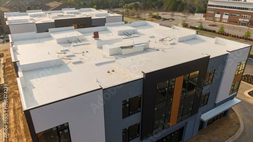 Aerial drone inspection of commercial TPO roof featuring heat-welded seams, HVAC curb flashing, and pipe penetrations.