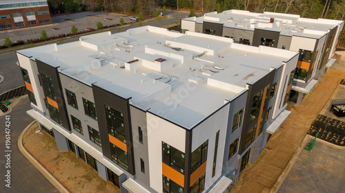 Aerial drone inspection of commercial TPO roof featuring heat-welded seams, HVAC curb flashing, and pipe penetrations.