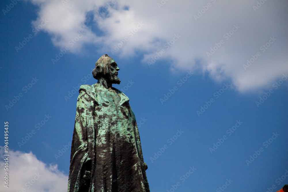 Fototapeta premium Bronze Statue Against Blue Sky Dramatic Perspective