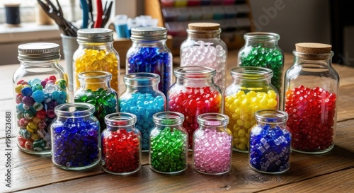 Assortment of glass jars filled with vibrant, colorful beads in various shades, arranged on a wooden surface with additional crafting supplies visible in the background, capturing a creative and...