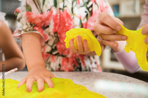 Quadro su tela Children playing with bright stretchy slime exploring sensory textures and creat