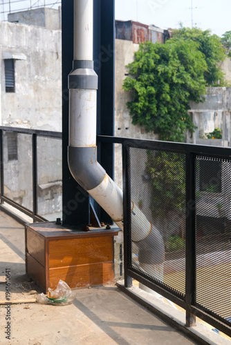 Фотография Large drainage pipe installed to channel rainwater from rooftop to ground, illustrating building water disposal system and urban rainwater management infrastructure on exterior wall