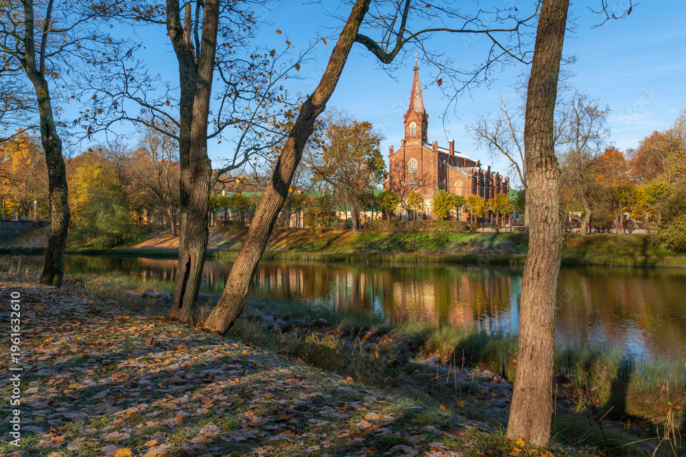 Fototapeta premium Lutheran Church of the Resurrection of Christ in Tsarskoye Selo on the bank of the 4th Lower Pond on a sunny autumn day, Pushkin, St. Petersburg, Russia