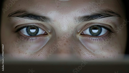 Close up of eyes reflecting screen light during deep focus