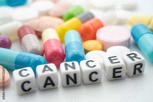 Cancer word with pills and capsules medical drug.