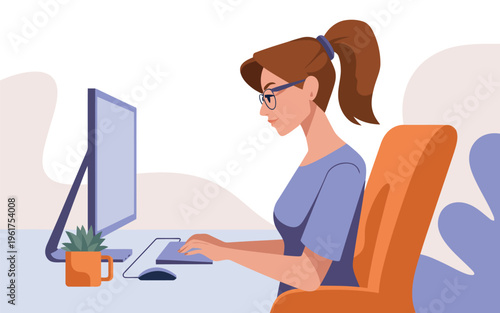 Diligent young woman wearing glasses and a blue top concentrating on her work at a computer