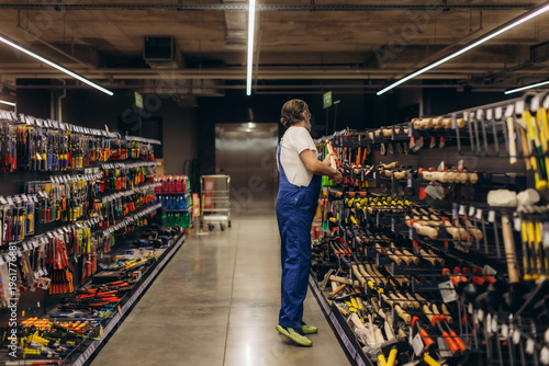 Tablou pe pânză Man shopping tools in hardware store aisle