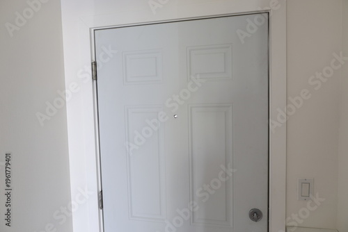 Canvas Print Full view of a closed white front door with peephole and lock