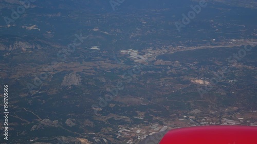 Aerial view of mountains, forests, and settlements in Turkey seen through an airplane window. Concept of air travel, tourism, and scenic landscapes from above. Journey, vacation, and exploration.