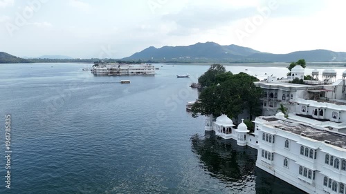 Aerial View of Peaceful Lake with Historic White Buildings and Mountains
