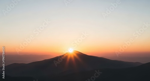 Majestic mountain peak bathed in the warm glow of a radiant sunrise over a serene horizon