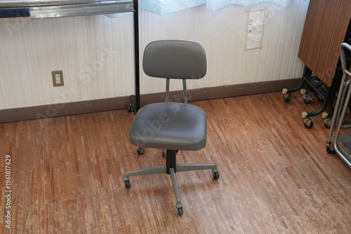 Photography Gray office chair sits idle on wooden floor