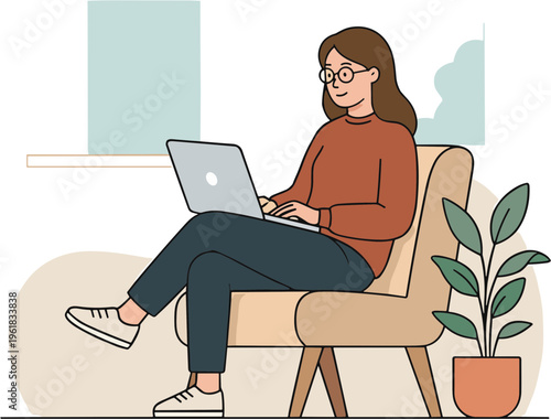 Woman sits on chair working on laptop with plant beside her indoors