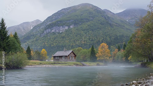 Scenic Landscape Featuring a Wooden Cabin by a River in Autumn Mountains. Seamless loooing 4k video background