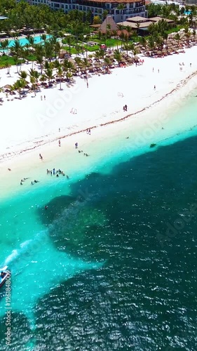 Aerial view of tropical beach, luxury resort with white sand on bright sunny day