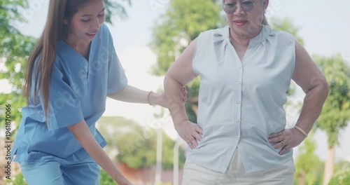 Professional physiotherapist helping a senior woman practice leg lift exercises for balance and strength.