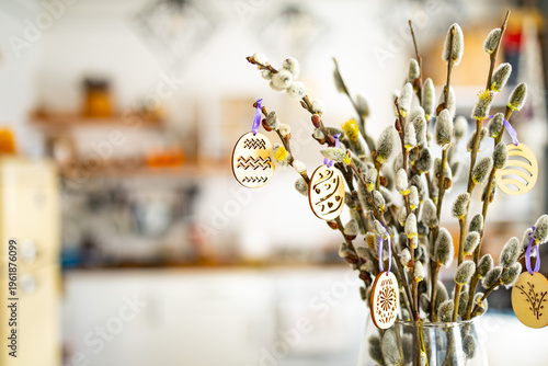 Tableau sur toile On the kitchen table wooden Easter eggs are placed on the branches of a flowering willow