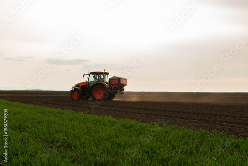 Quadro su tela Tractor spreading artificial fertilizers in field