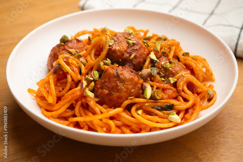 Hearty spaghetti and meatballs in a rich tomato sauce, garnished with fresh basil leaves