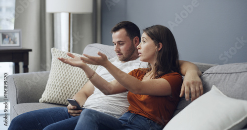 Obraz na plátně Phone, argue and couple watching tv on couch, bonding distraction or upset for missing movie scene