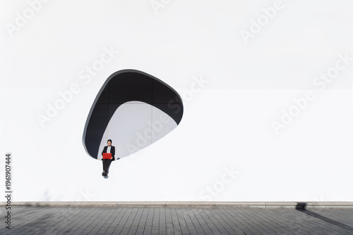 Businesswoman with red laptop working on modern Barcelona architecture