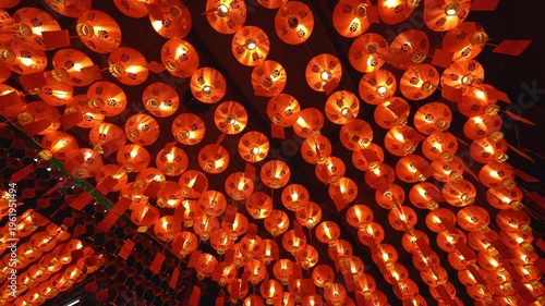 Experience the vibrant glow of traditional Chinese lanterns in a Thai shrine. This smooth panning 4K shot captures the intricate details and warm atmosphere of a Lunar New Year celebration, perfect fo