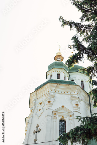 Obraz na plátně White orthodox church with green domes and golden crosses against a clear sky