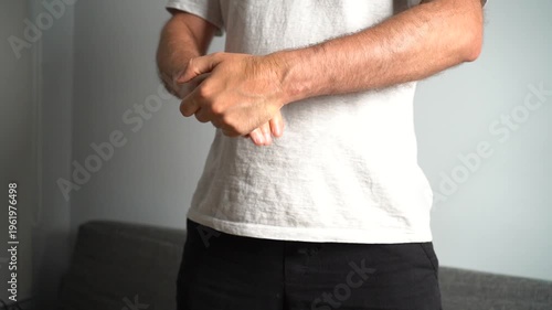 Young man massaging his painful wrist due to carpal tunnel syndrome, arthritis or injury